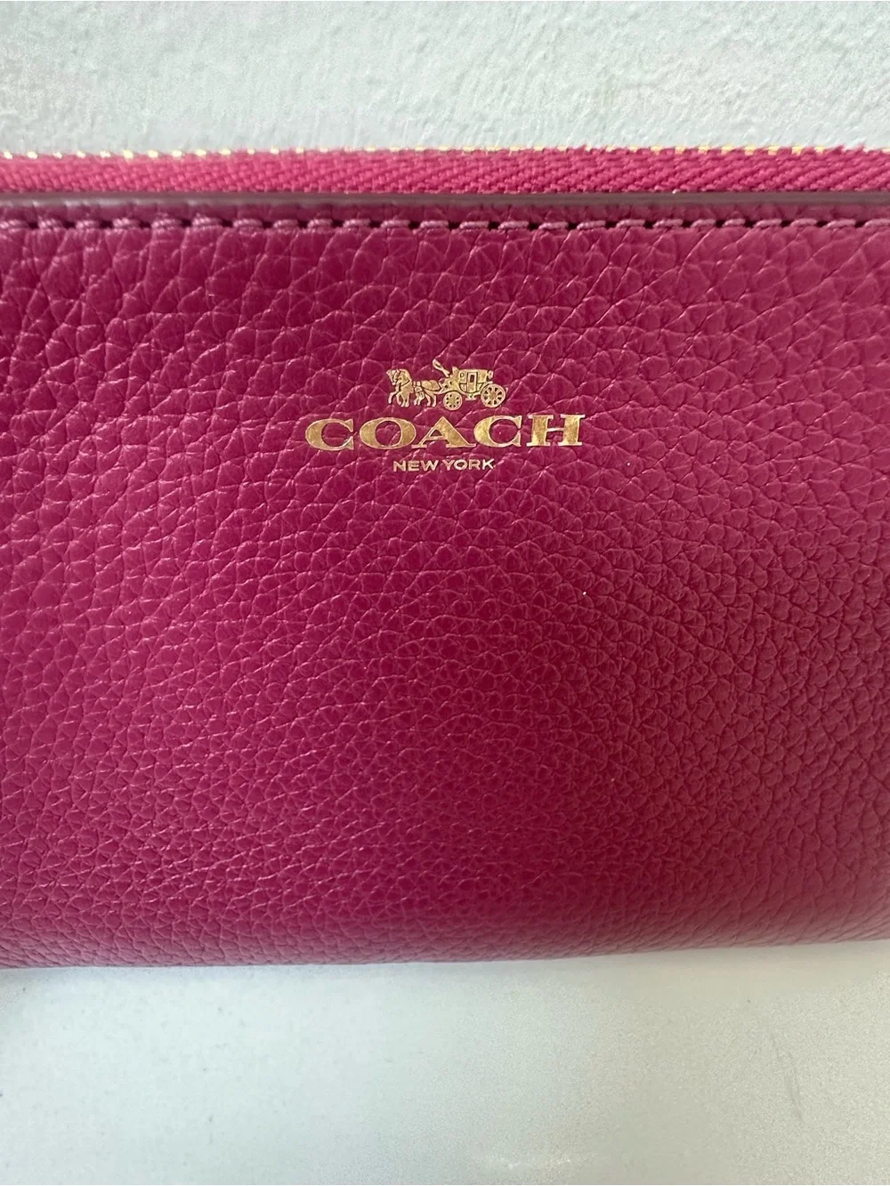 Coach corner zip wristlet in wine plum color.